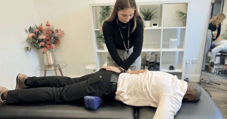 Practitioner assessing a patient’s shoulder and neck during musculoskeletal treatment