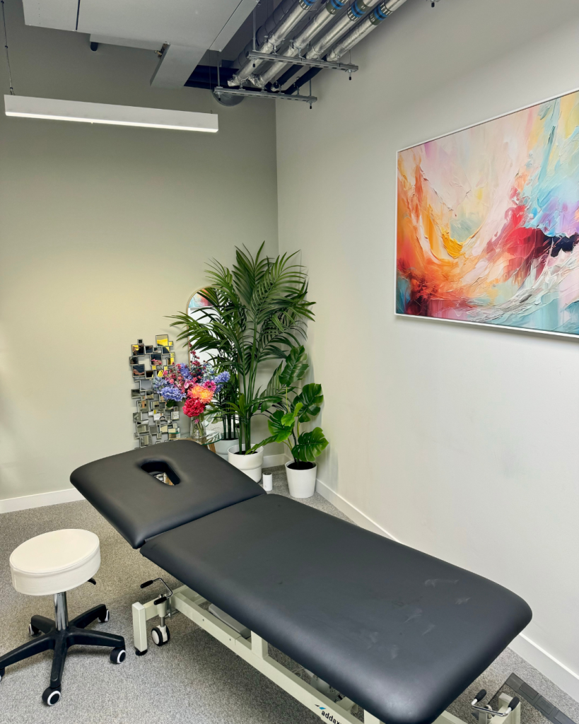 Top London Chiropractor's beautiful clinic room of a Chiropractor Pimlico with Bench, Flowers and artwork at Battersea and Chelsea Chiropractic