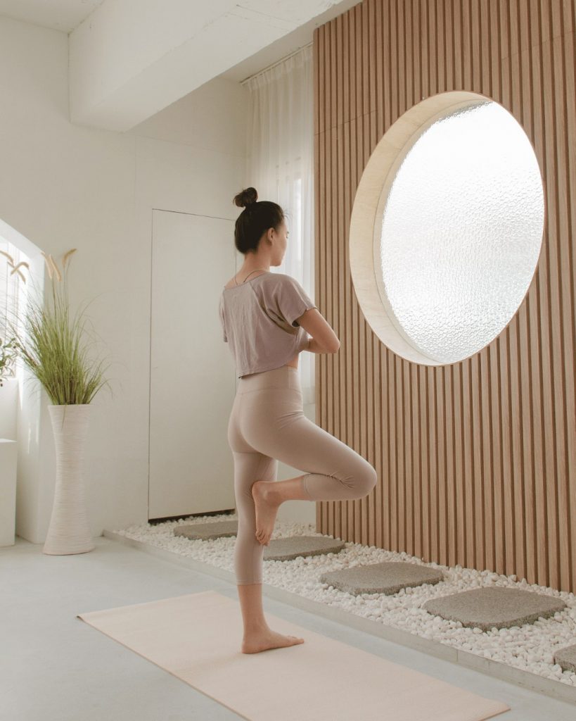 Female patient stretching and smiling after chiropractic care from a London chiropractor Victoria clinic.