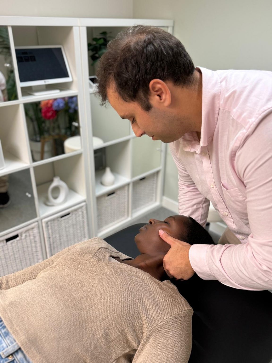 image showing a patient undergoing a chiropractic assessment for neck pain in a modern London clinic, created for Battersea & Chelsea Chiropractic.